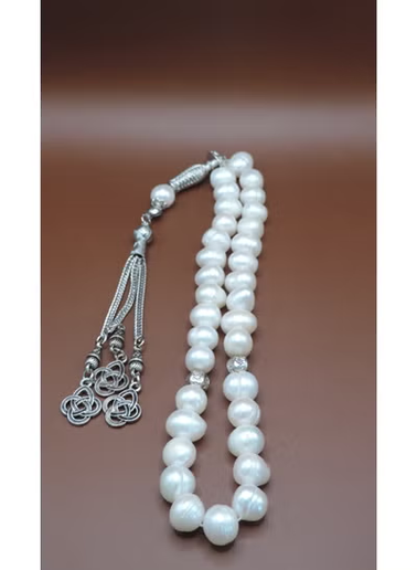 Pearl necklace with silver clasp on a brown background